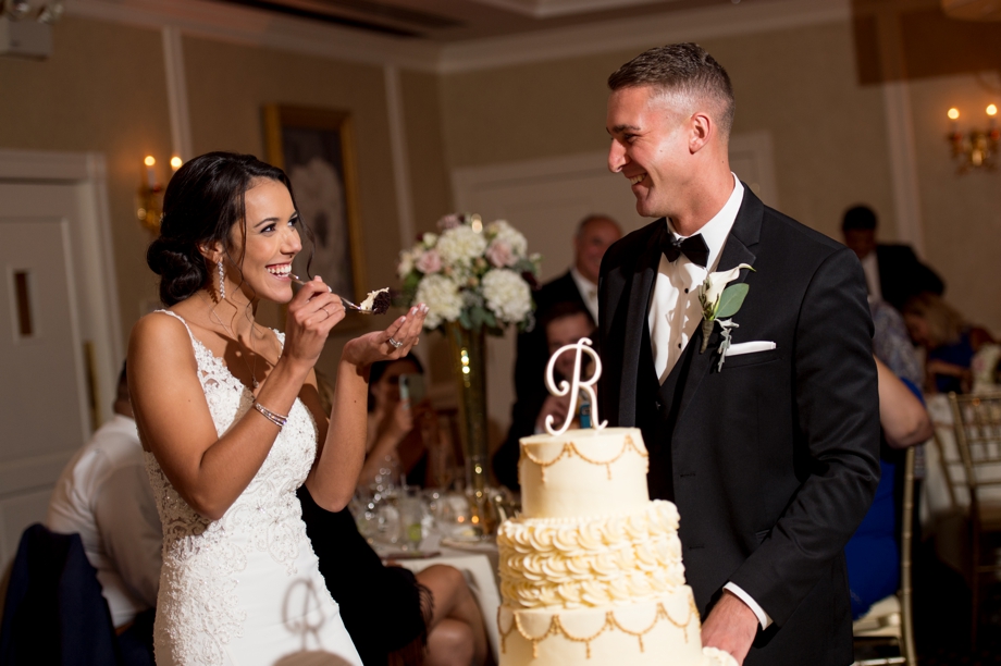 Bride and groom feeding each other cake at their New Seabury Country Club wedding