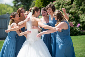 Bride hugging her bridesmaid as they see her for the first time in her wedding dress 