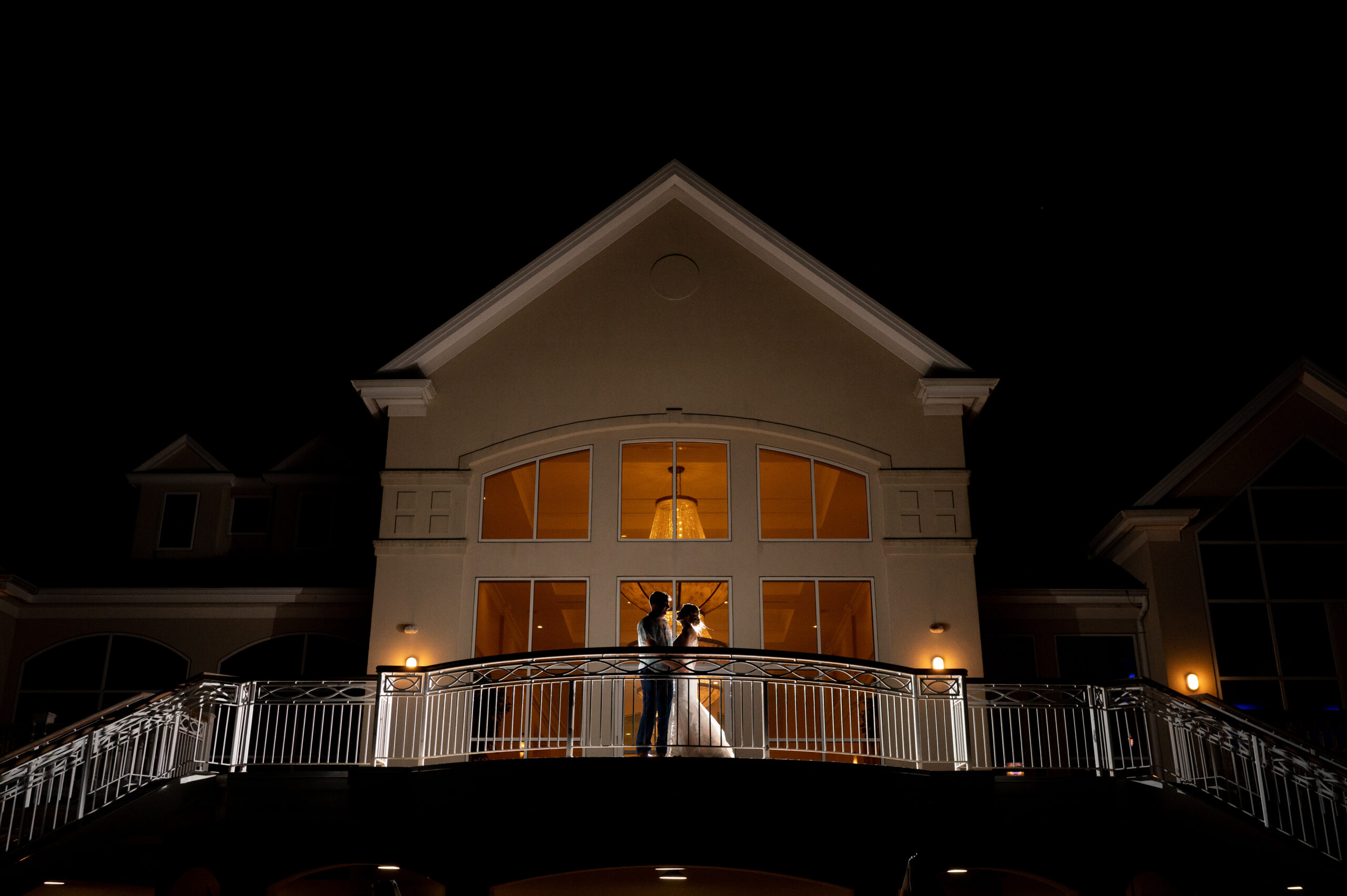 bride and groom kissing on balcony after wedding day celebration