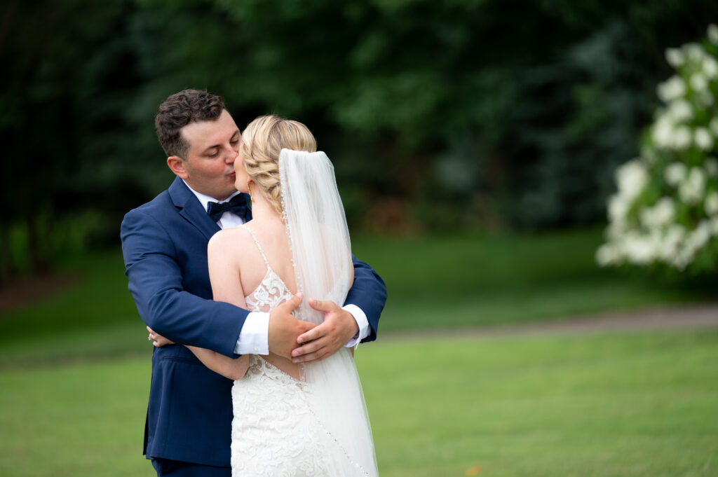 bride and groom kissing after their wedding day first look