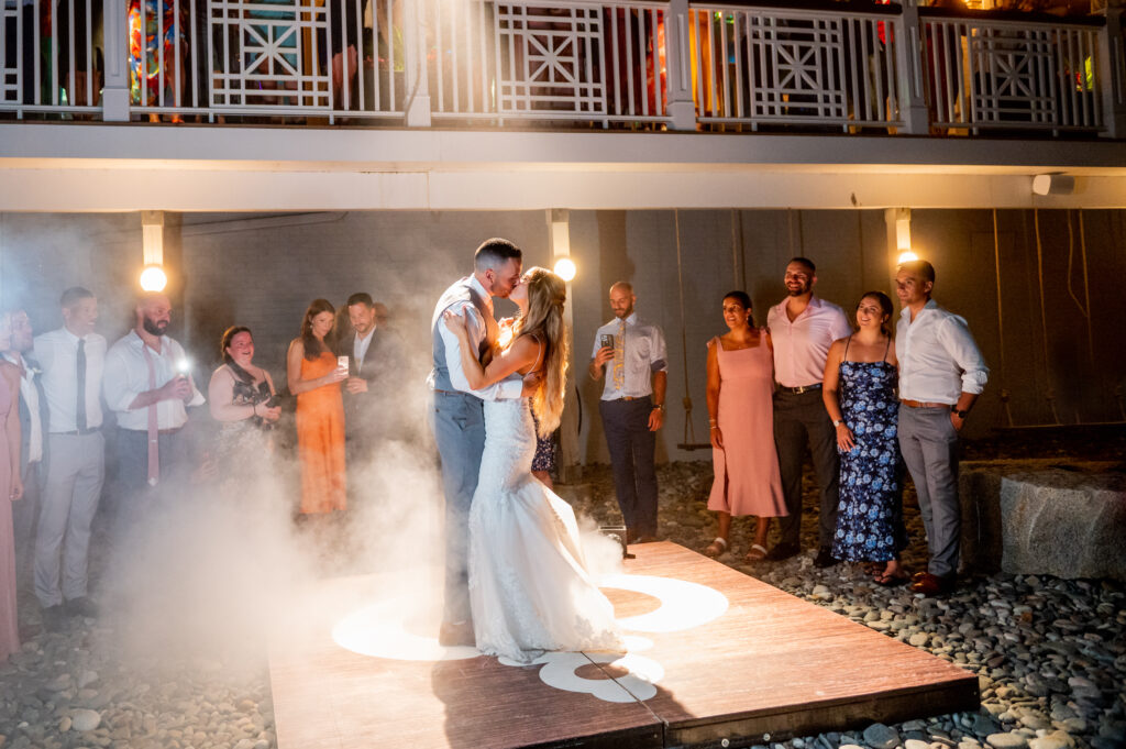 bride and groom on the dance floor while guests watch