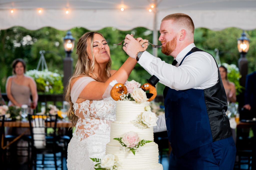 bride and groom feeding each other wedding day cake