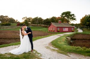 Groom dipping bride in front of the barn at the willowbend country club