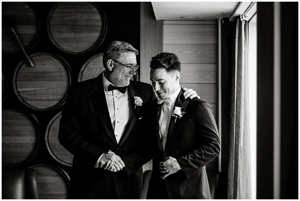 groom's father gives him a handshake before the wedding