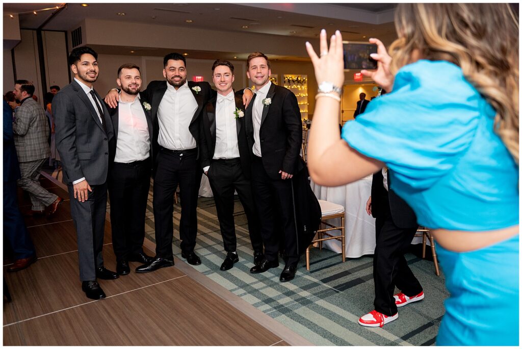 guest takes picture with iphone of groom and his friends during the Newport Marriott Hotel Wedding 