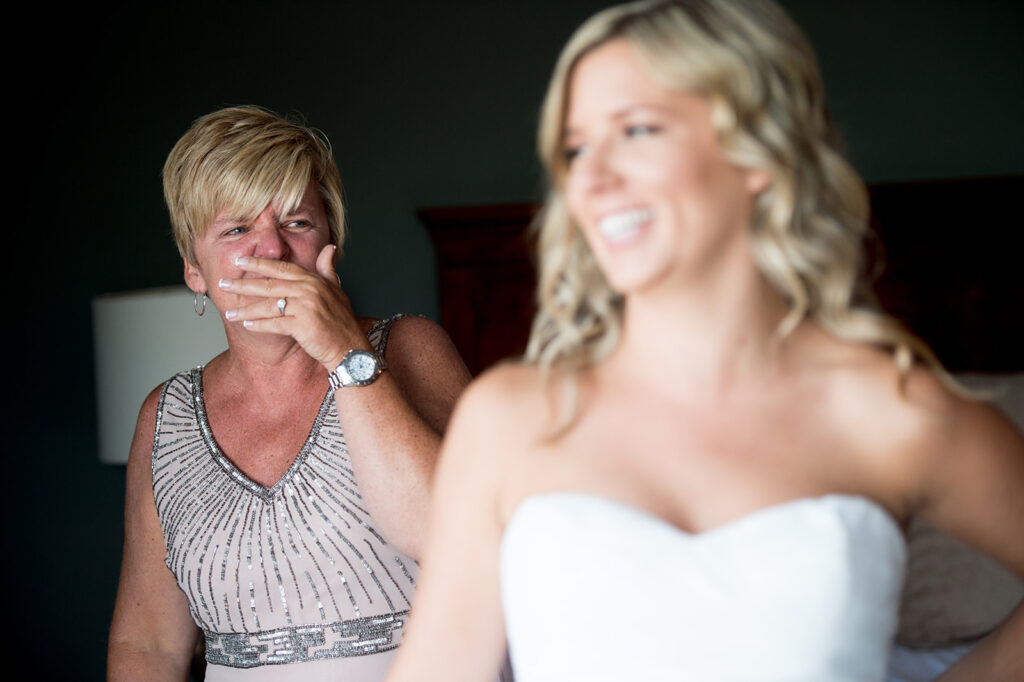 mom of bride cries as she sees her daughter in her wedding dress 