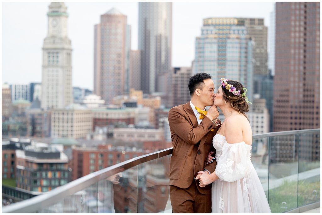 bride and groom kissing on a boston rooftop 