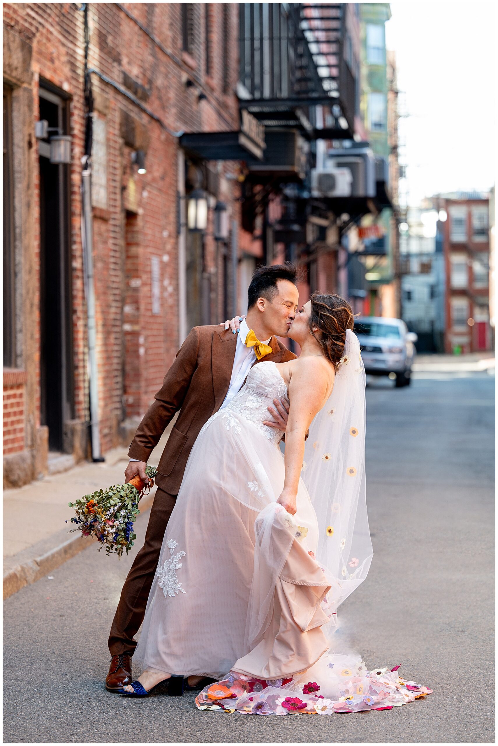 bride and groom kiss in the middle of the boston street 