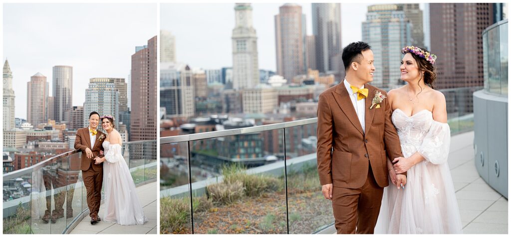 bride and groom smile at the camera on the rooftop with boston skyline behind 
