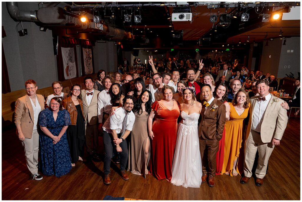 a large group photo of all the wedding guests with the bride and groom 