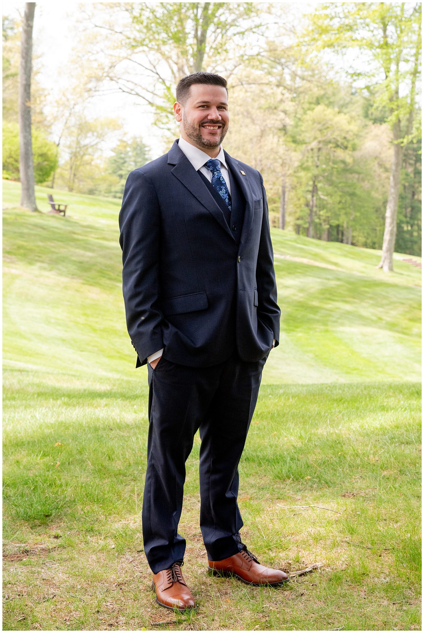 the groom standing on a grassy knoll with sunlight