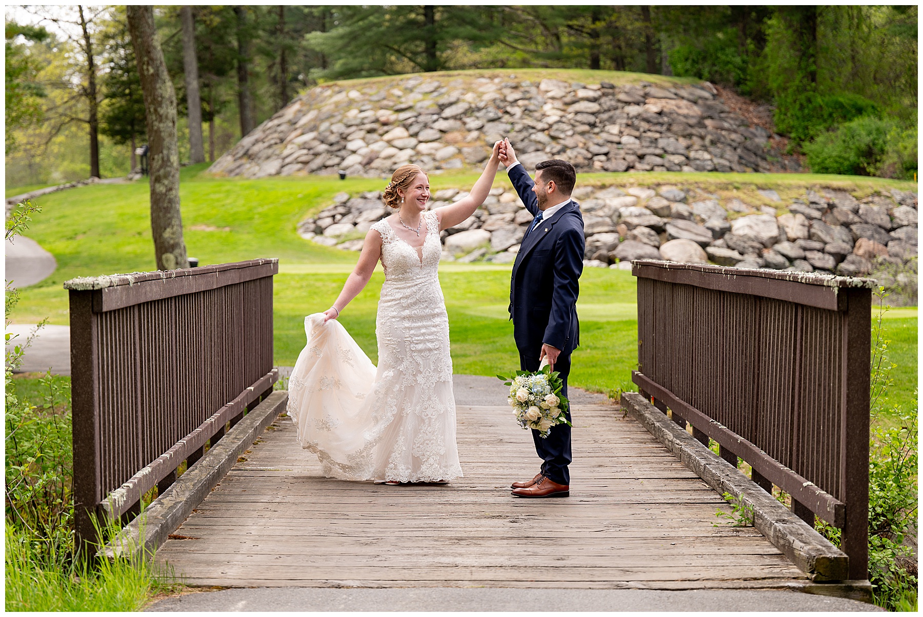 bride and groom dance on a brown bridge in front of a golf course