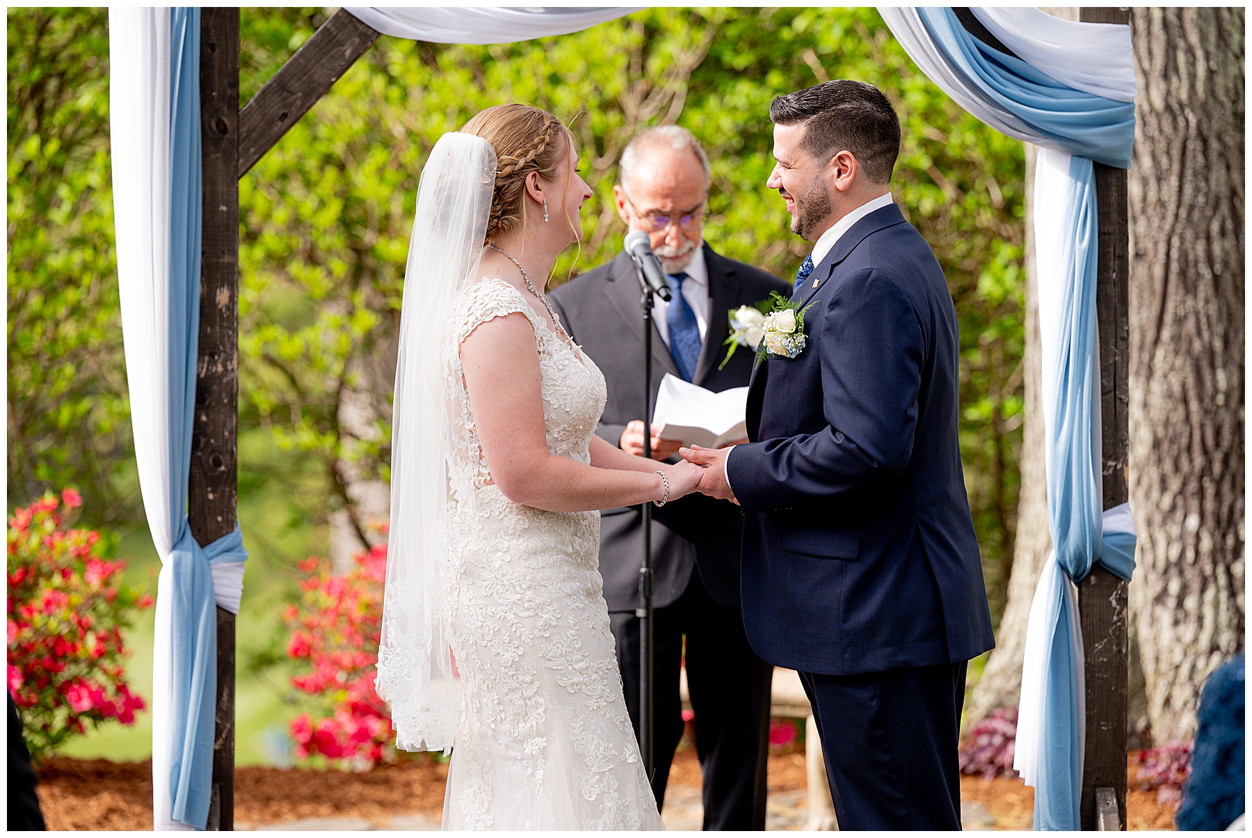 the bride and groom stand at the altar holding hands and smiling