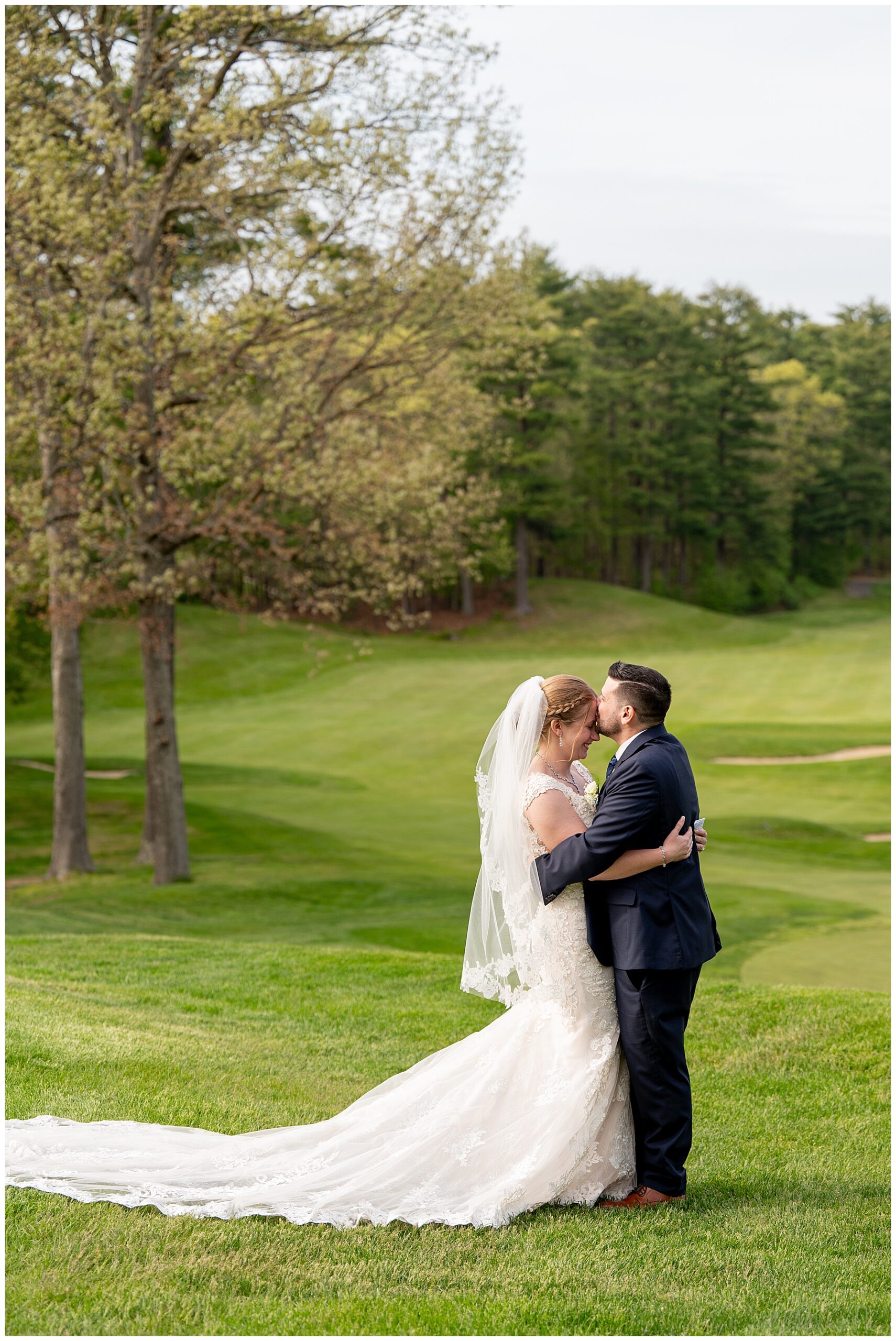 Groom kissing brides head as they hug