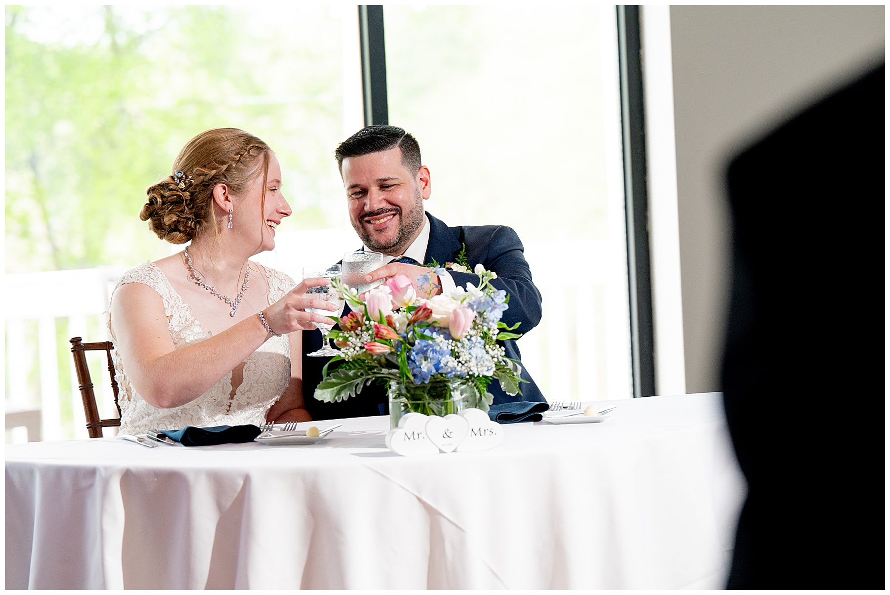 the bride and groom cheers glasses during their reception