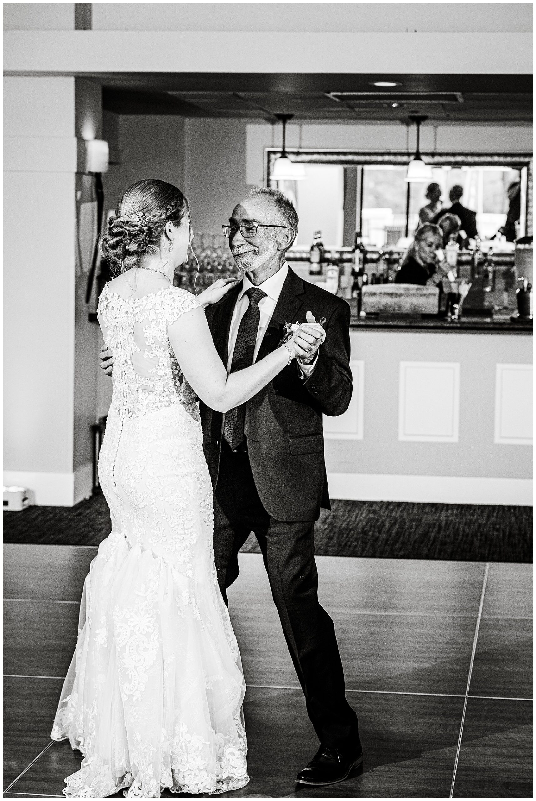 a black and white photo of the bride and her father dancing