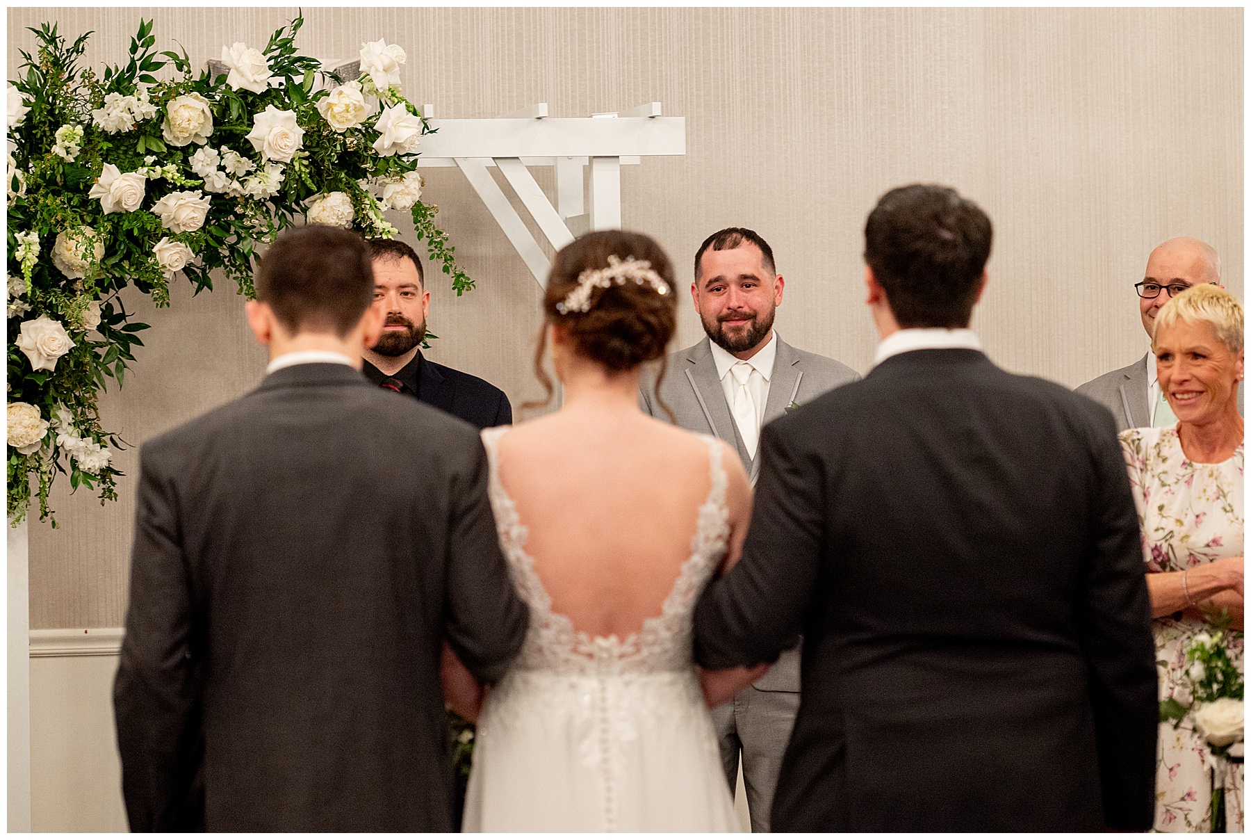 Groom looking at his bride coming down the aisle at inside wedding ceremony at the Chocksett Inn. 