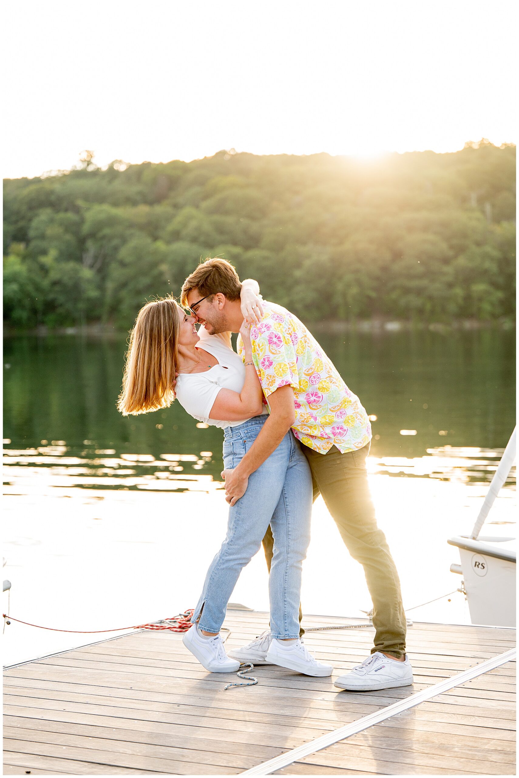 man and woman kiss during engagement session at boston's Jamaica Pond during sunset 