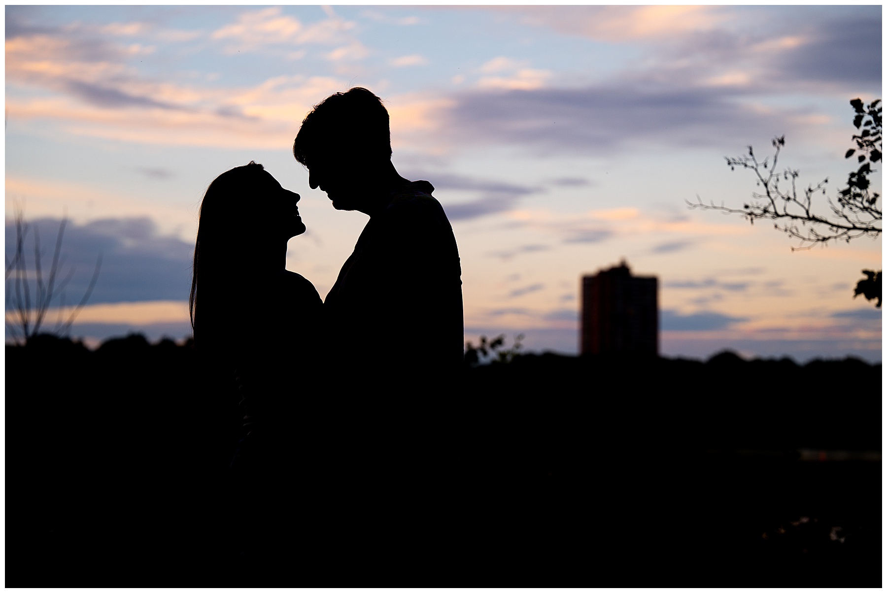 man and woman about to kiss as the sun sets behind them in boston, ma 