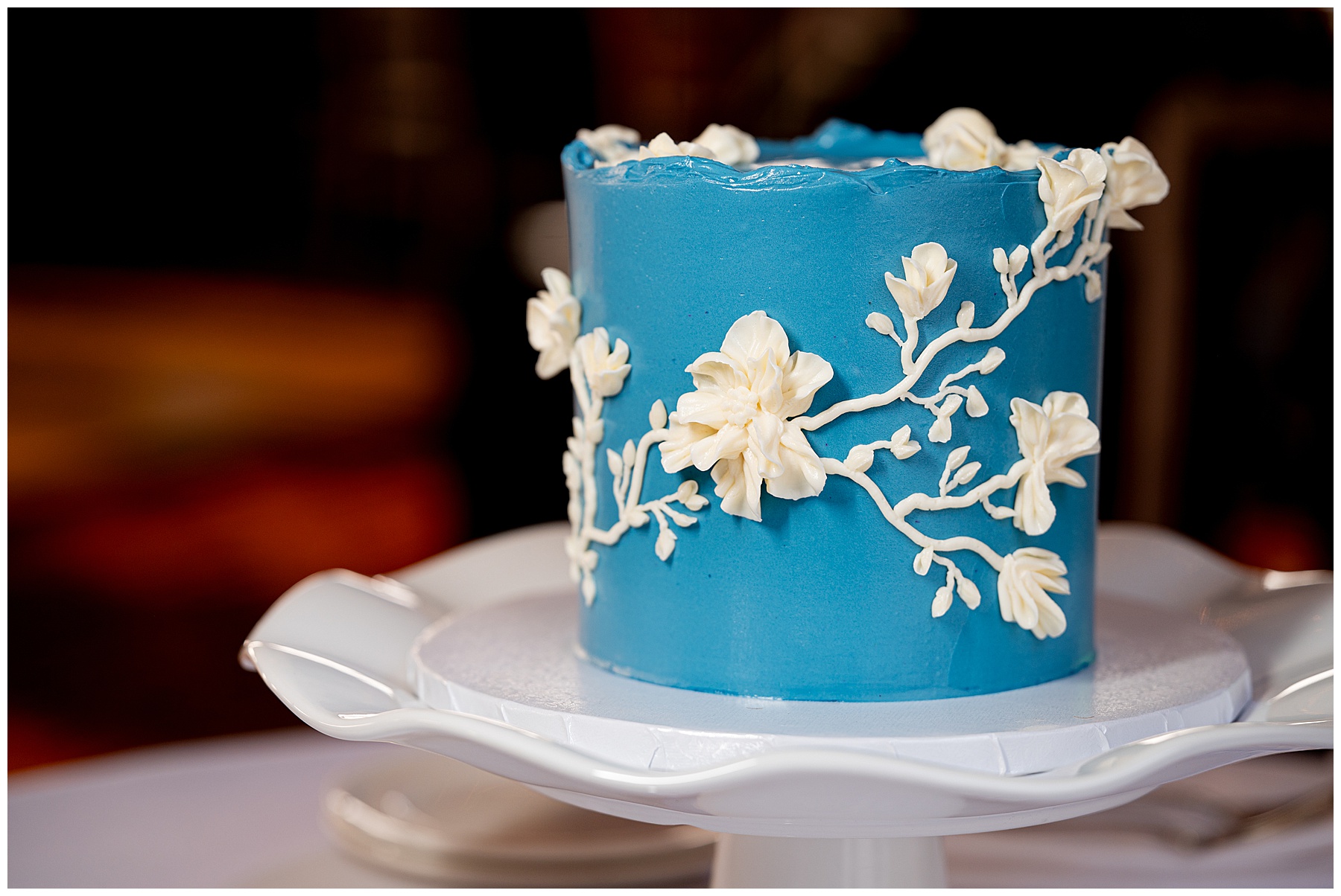 teal blue wedding cake with white flower and vine detailed icing