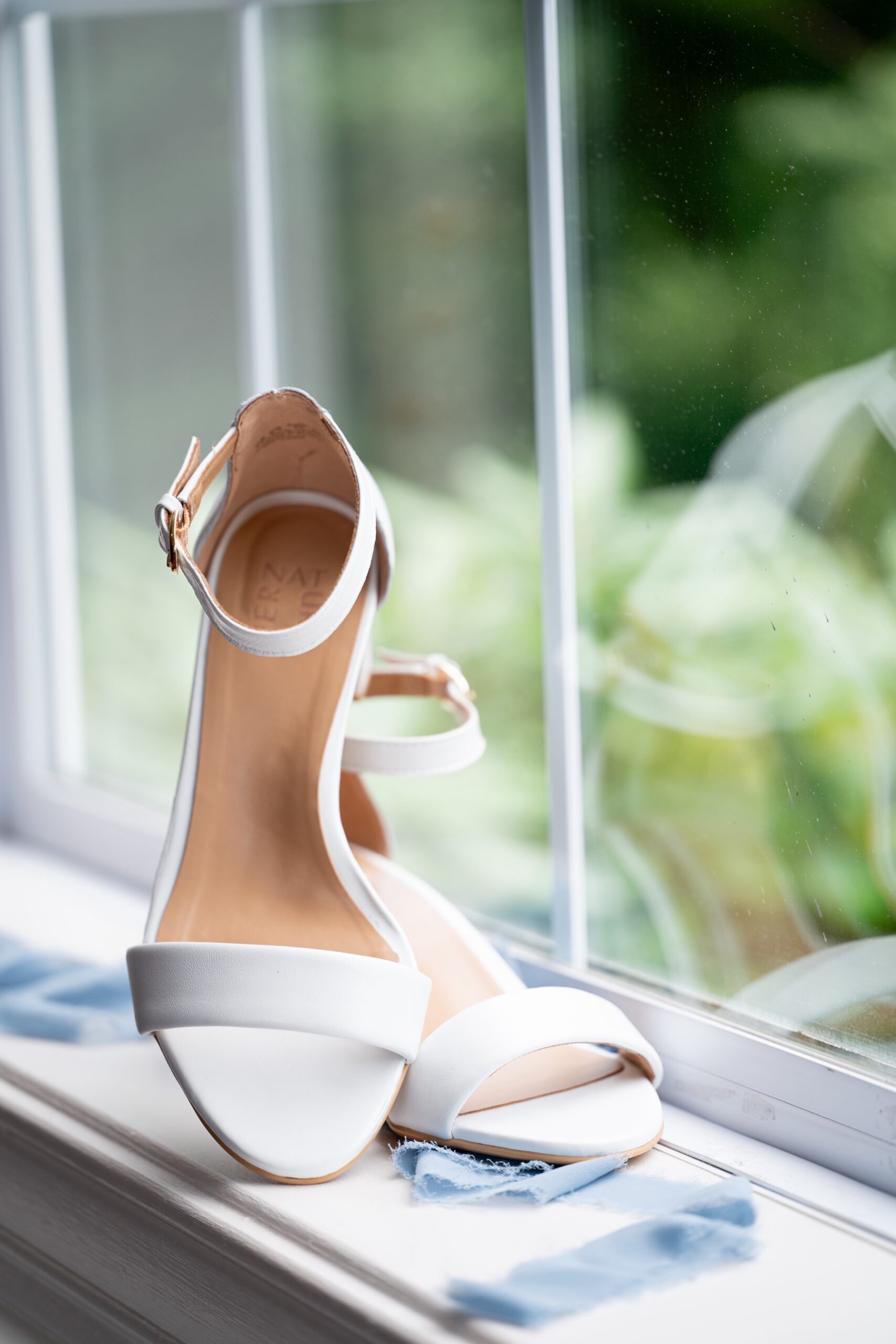 white wedding shoes sitting on window sill