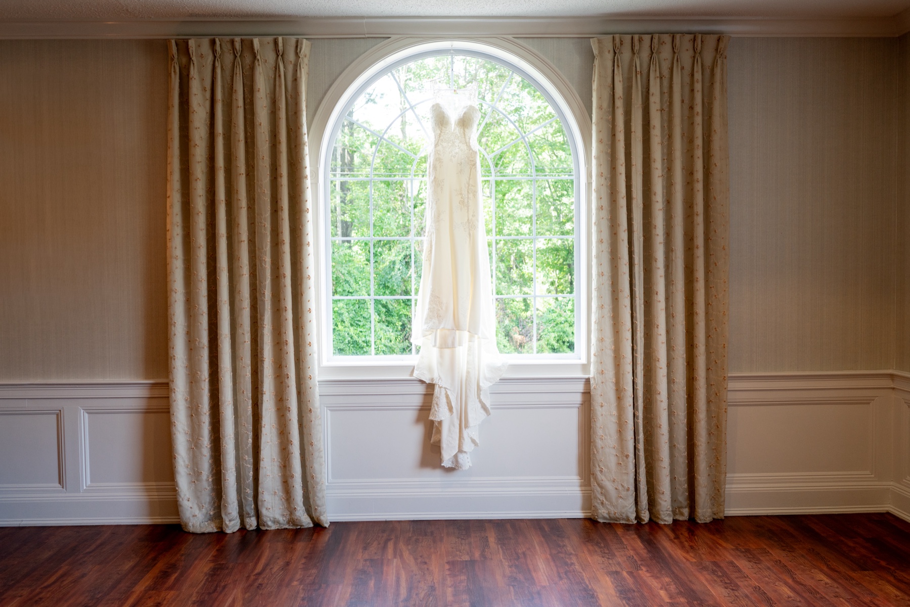 wedding dress hanging in window 