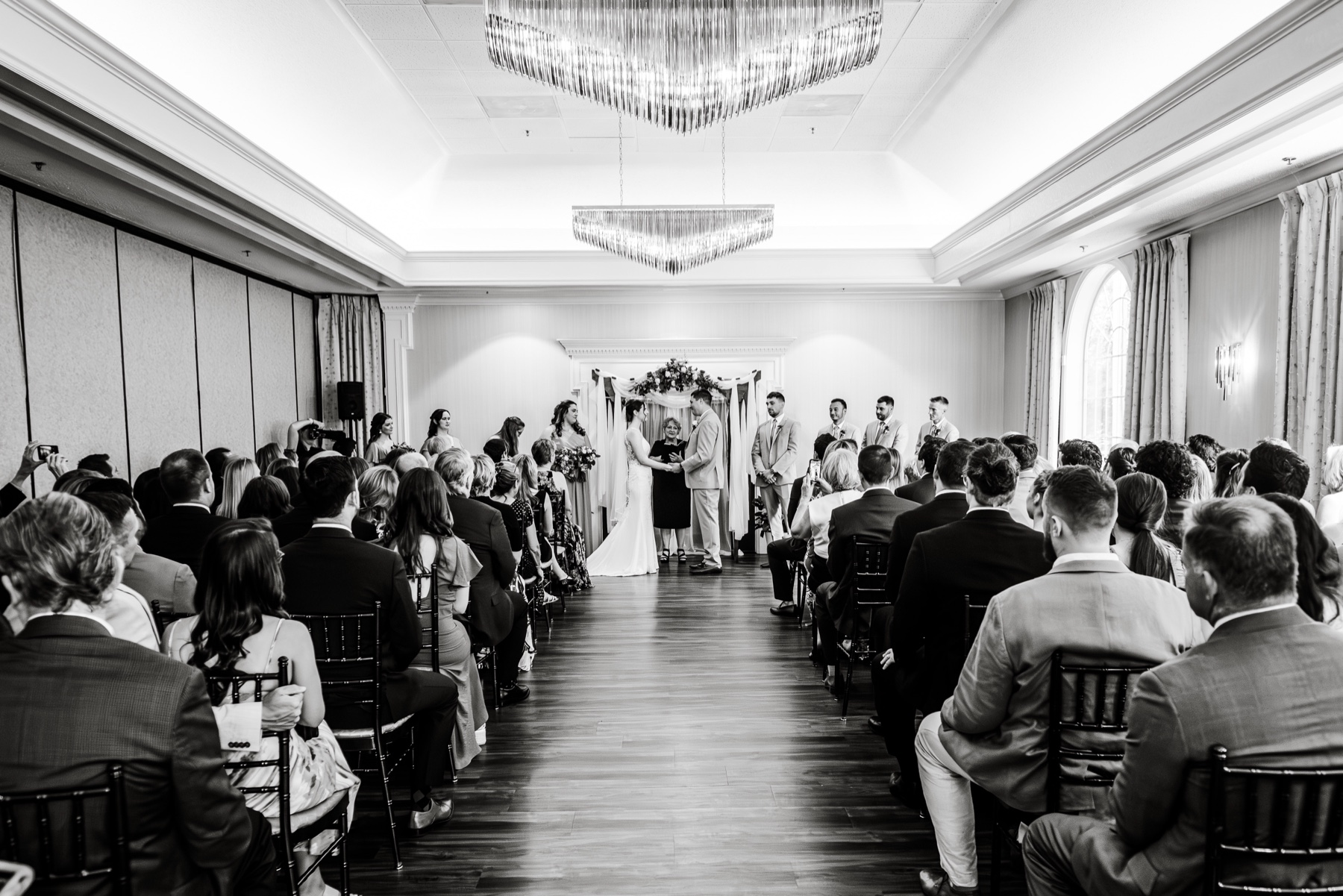 wide shot of the wedding ceremony full of guests 