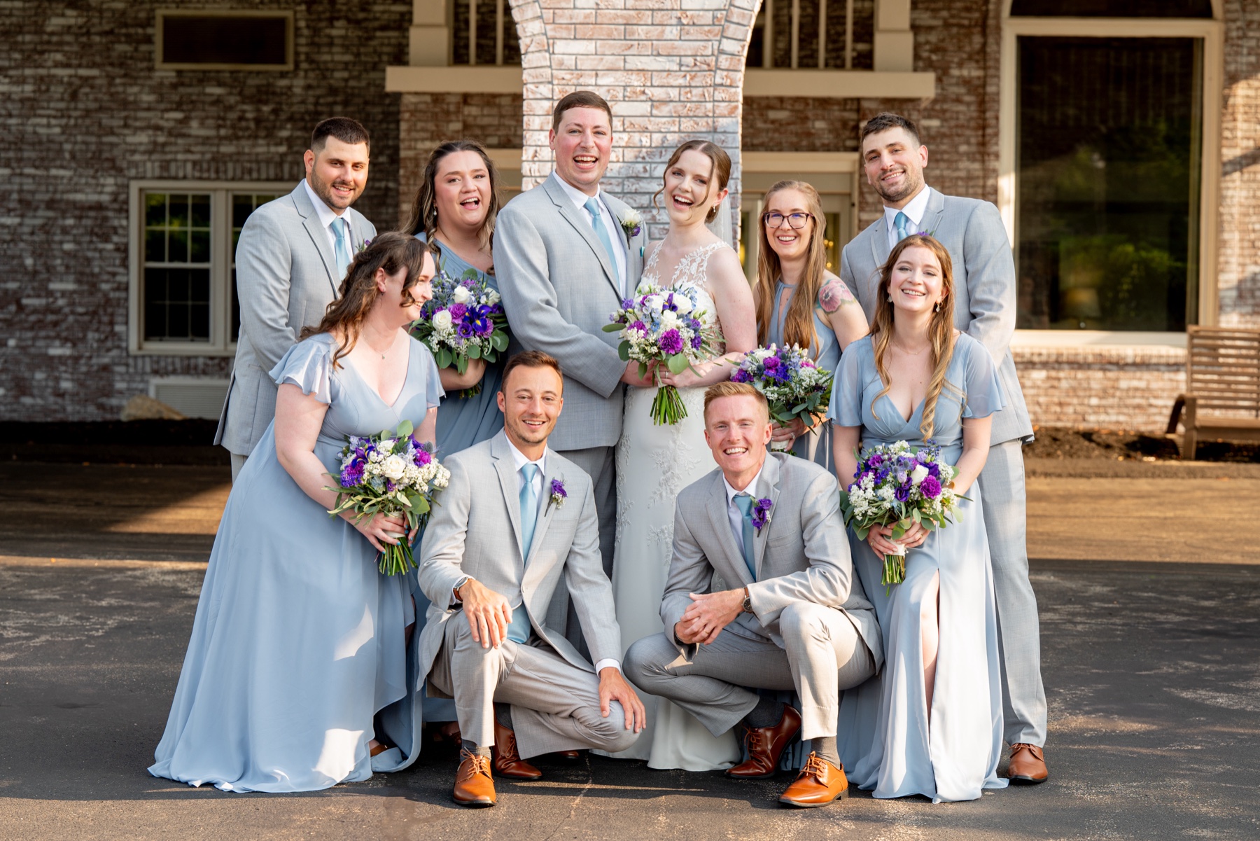 bride and groom posing with their wedding party 