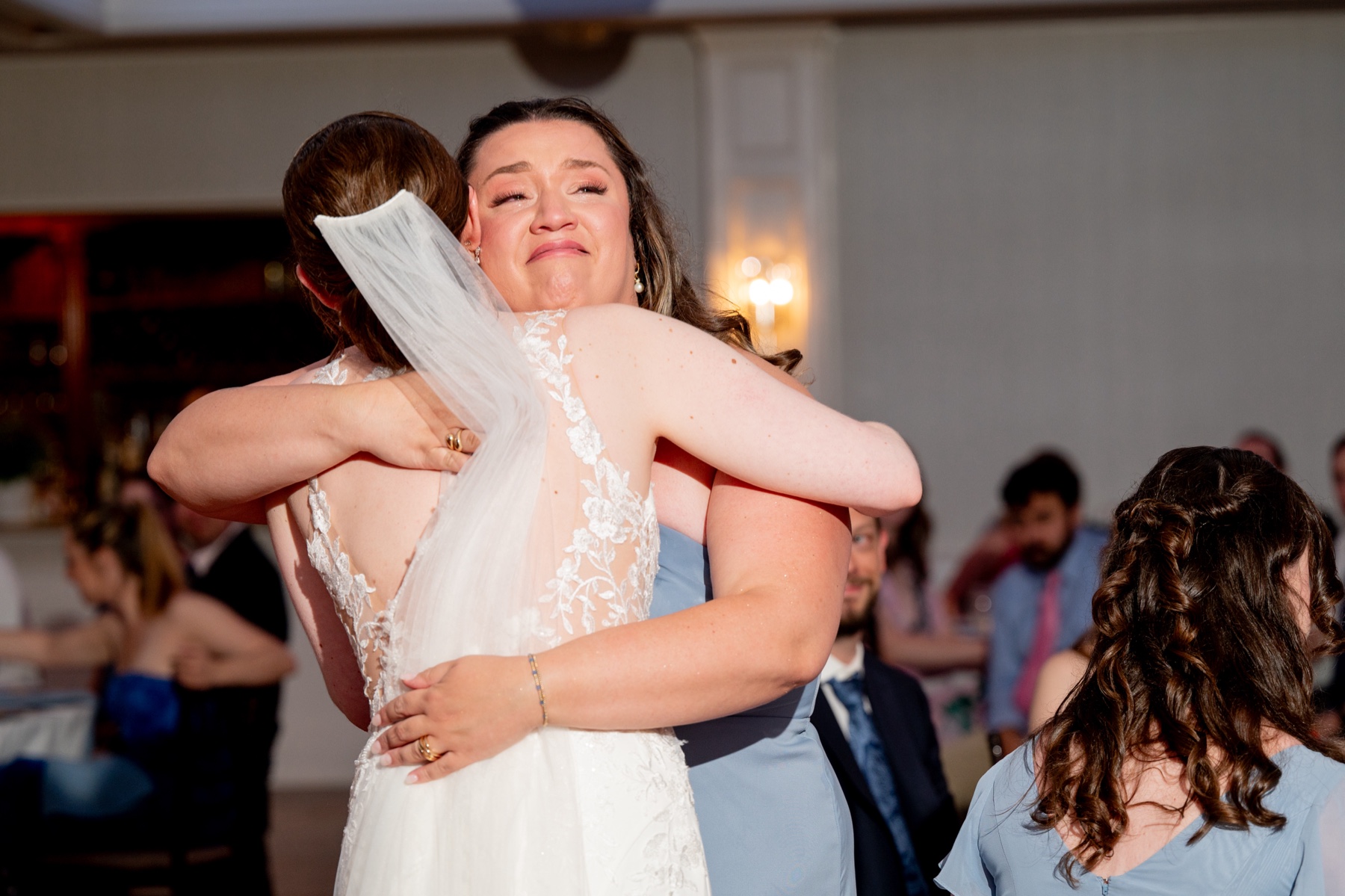 bride hugging bridesmaid after her wedding toast 