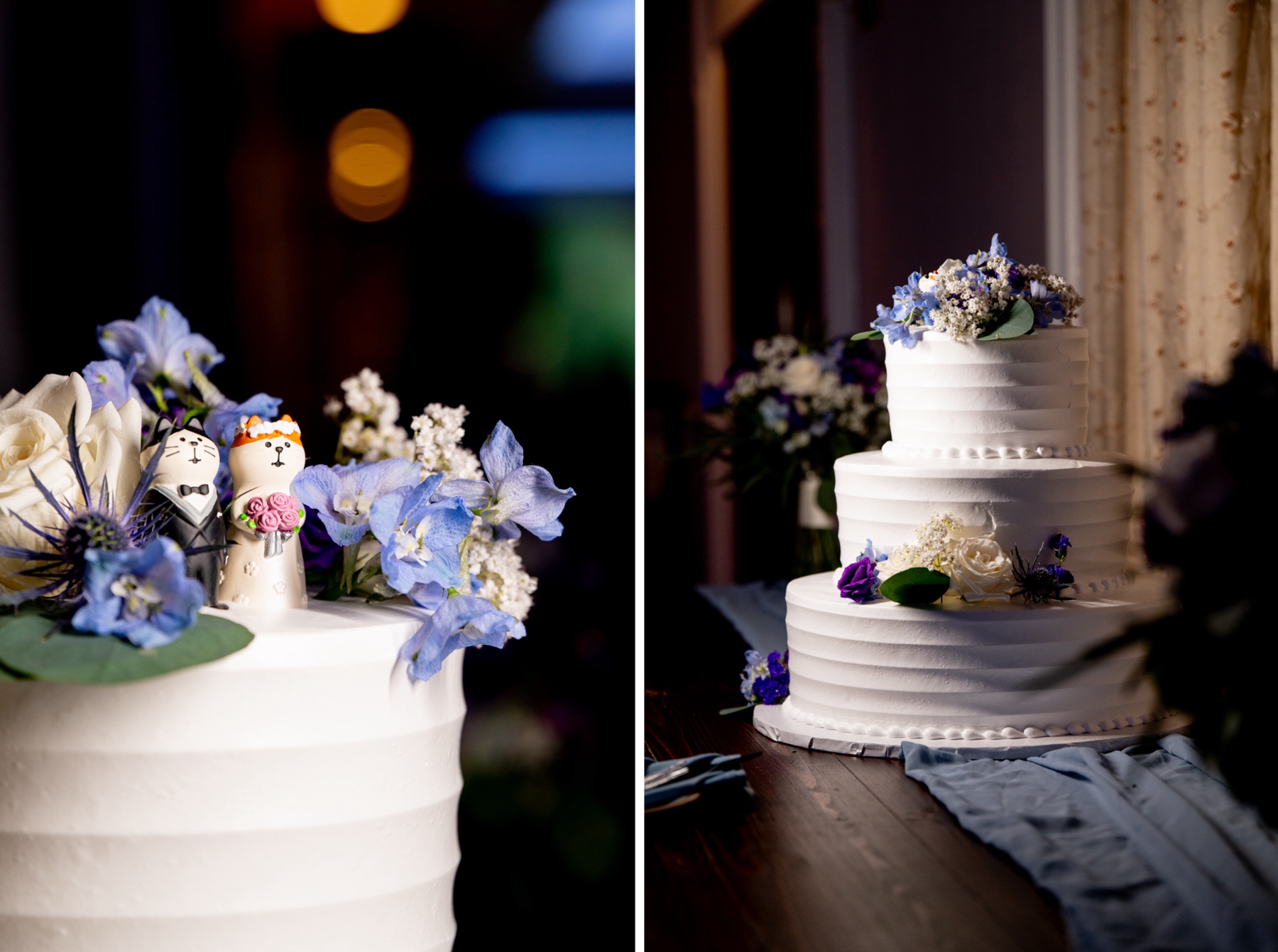 white wedding cake with blue and purple florals and cat figurines 