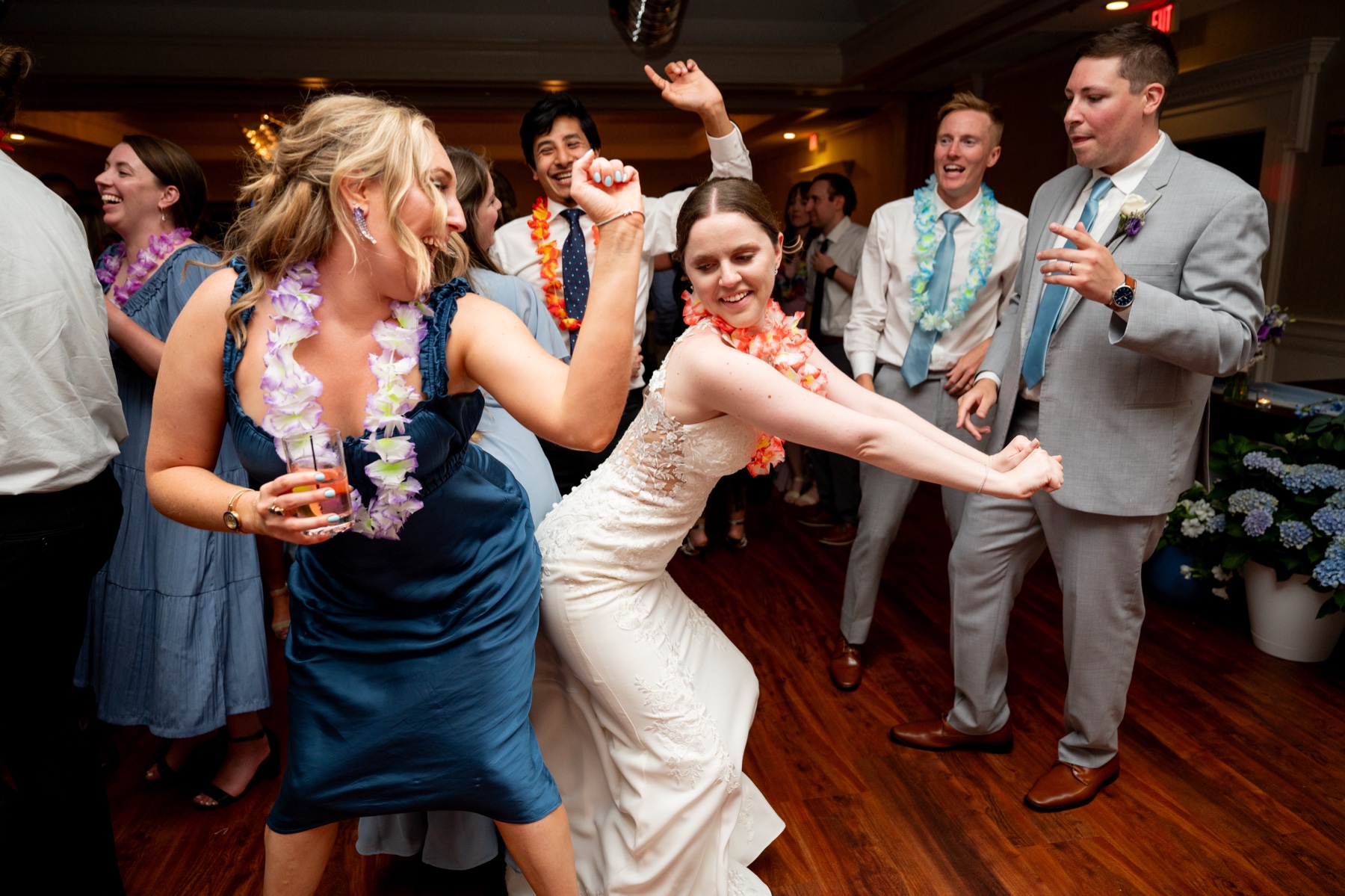 bride dancing with wedding guests wearing leis 