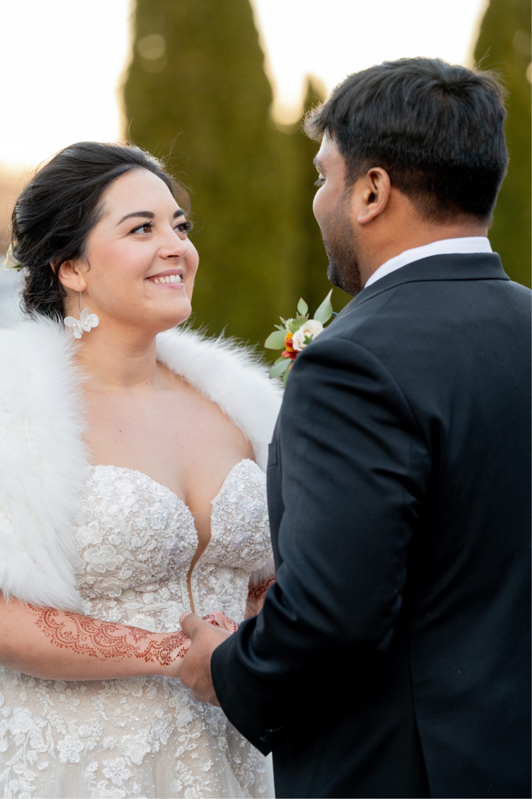 bride and groom holding hands and smile at eachother 