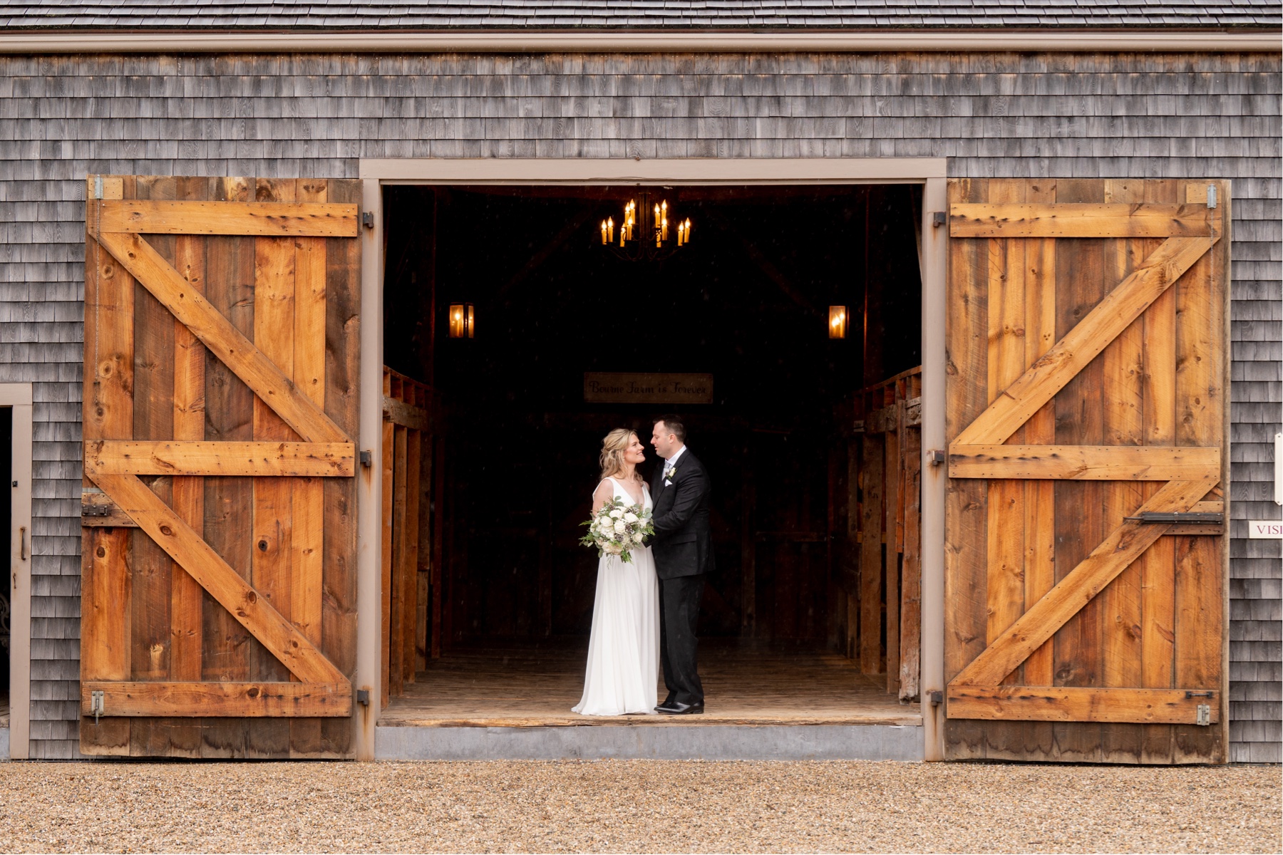 bride and groom standing in the doorway of a wooden barn for a Winter Wonderland Wedding