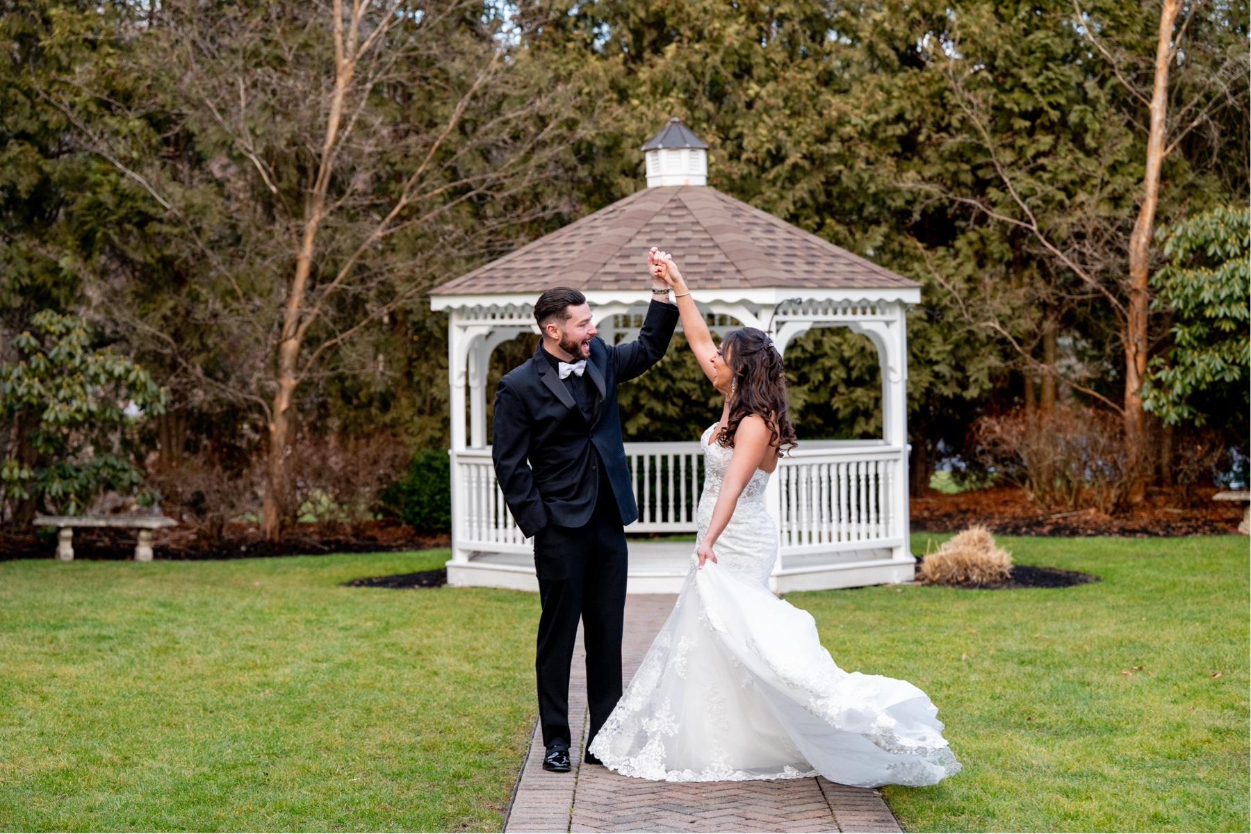 bride and groom dancing in front of white gazebo