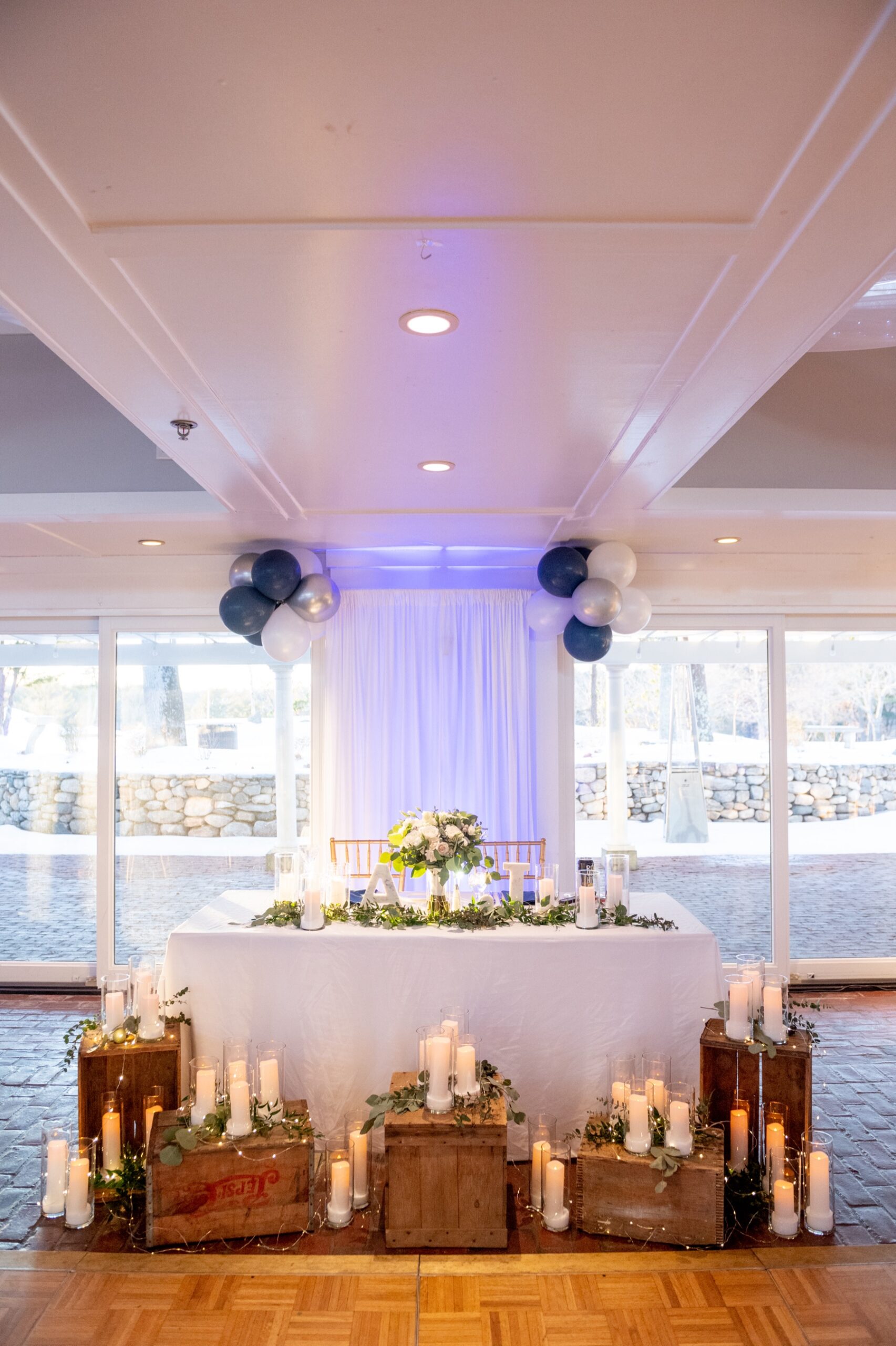 wedding reception decor of white candles and brown boxes and green florals for a Winter Wonderland Wedding