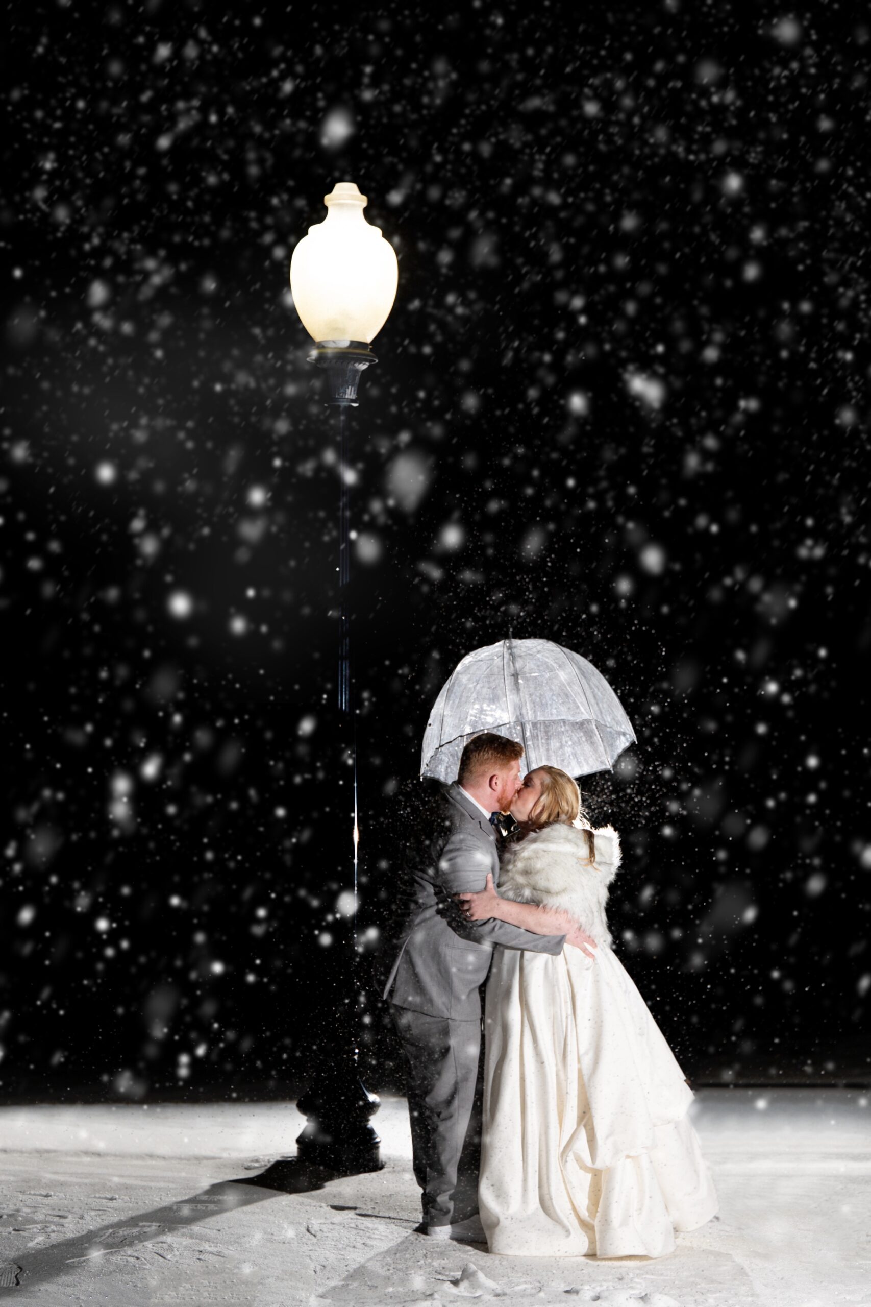 bride and groom kissing in the evening while it snows for a Winter Wonderland Wedding