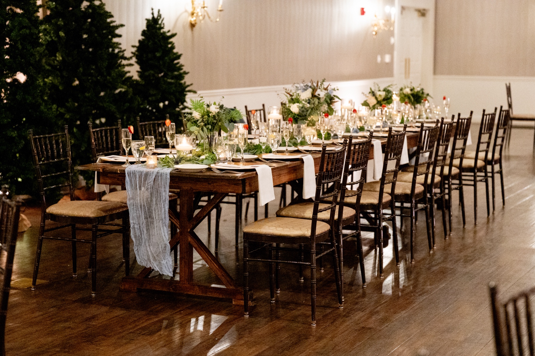 a Winter Wonderland Wedding reception filled with christmas trees and gold design accents