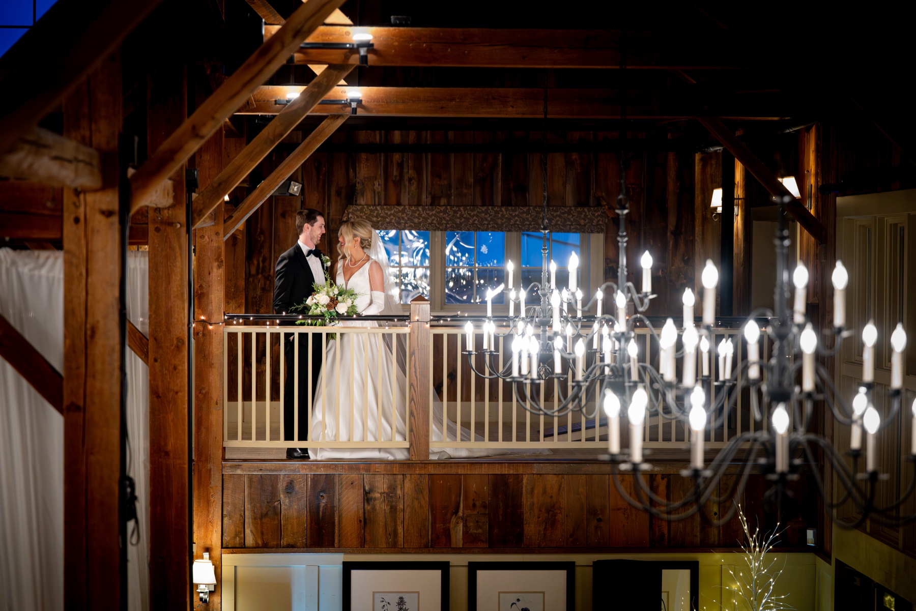 bride and groom standing in the loft of their Winter Wonderland Wedding reception inside an old barn