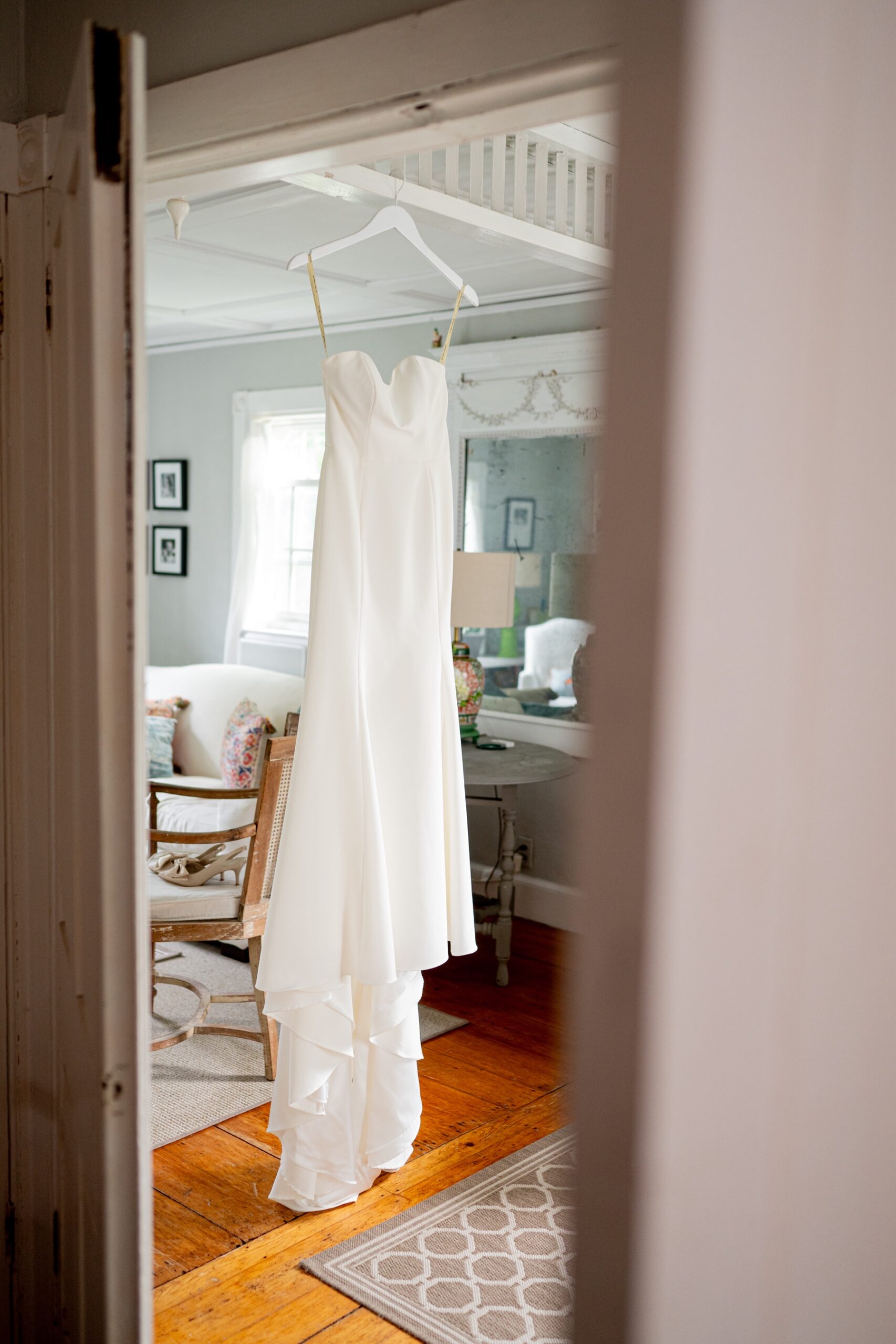 white bridal gown hanging in the hallway