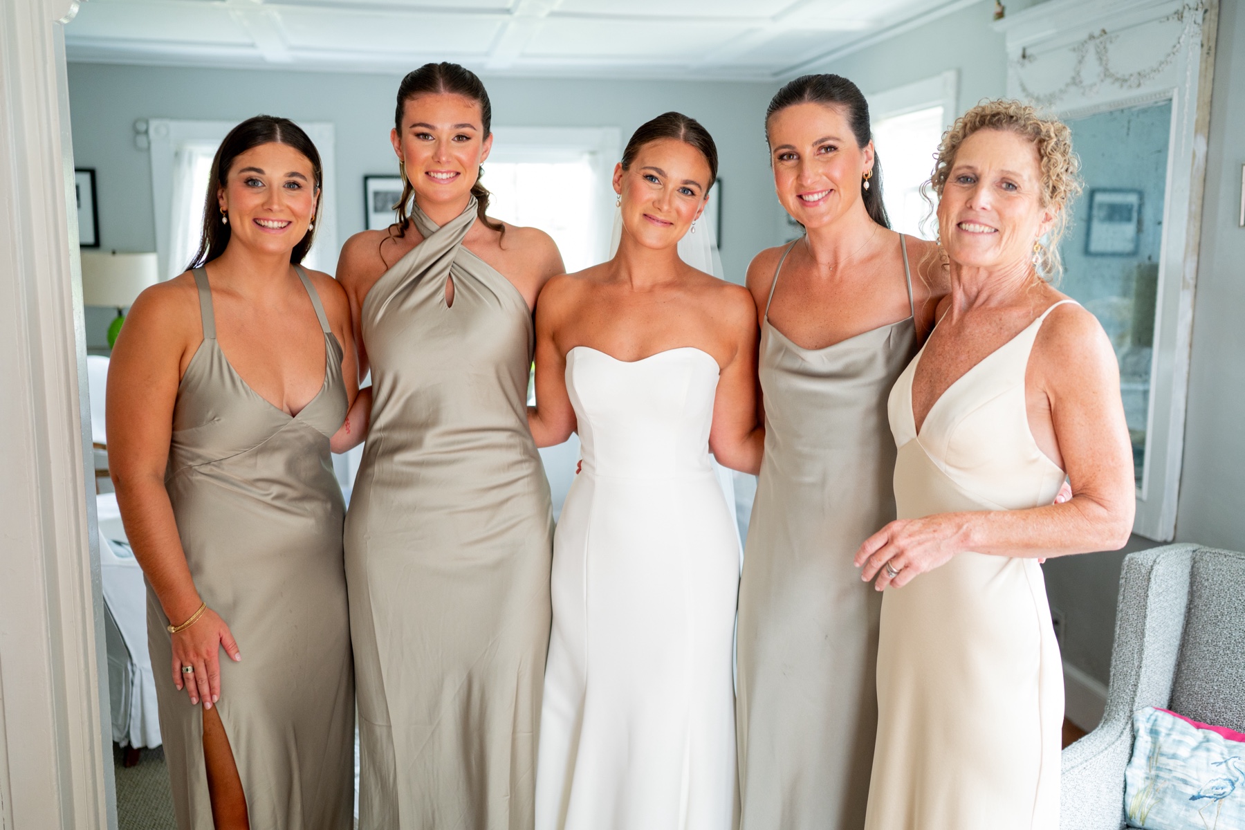 bride standing with her bridesmaids who wear light grey dresses on her South Shore Summer Wedding day 