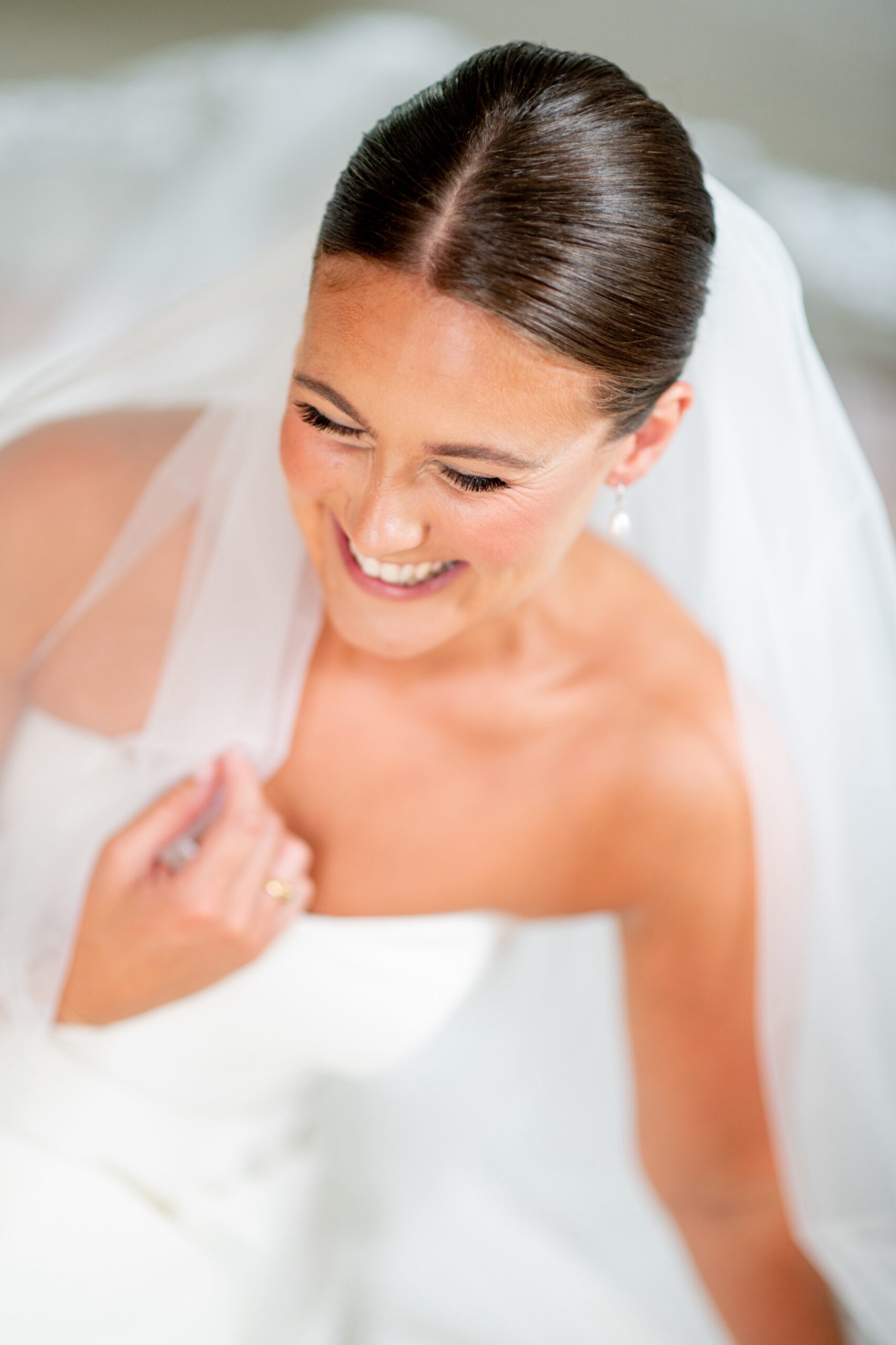 close up of bride smiling with her wedding dress and veil on 