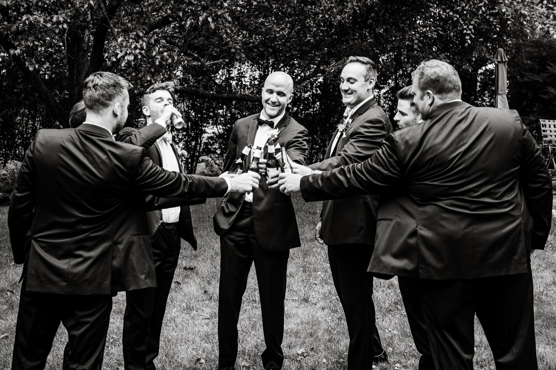 groom and groomsmen cheersing beers before the wedding 