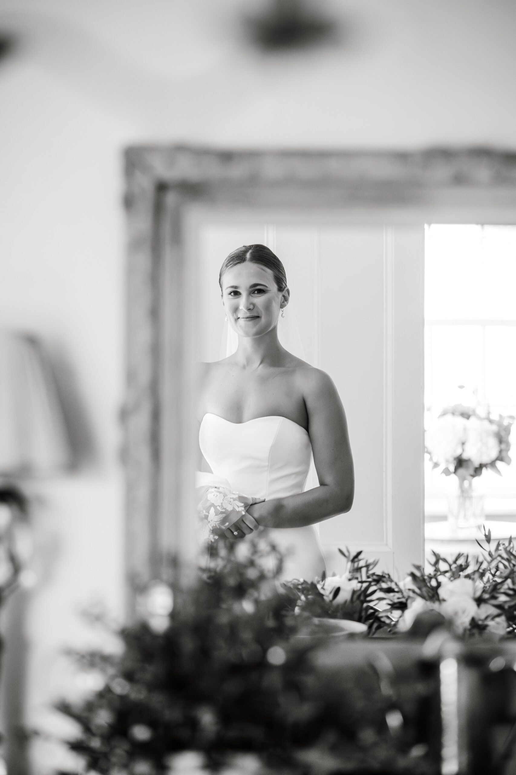 bride smiling in the mirror wearing her wedding dress