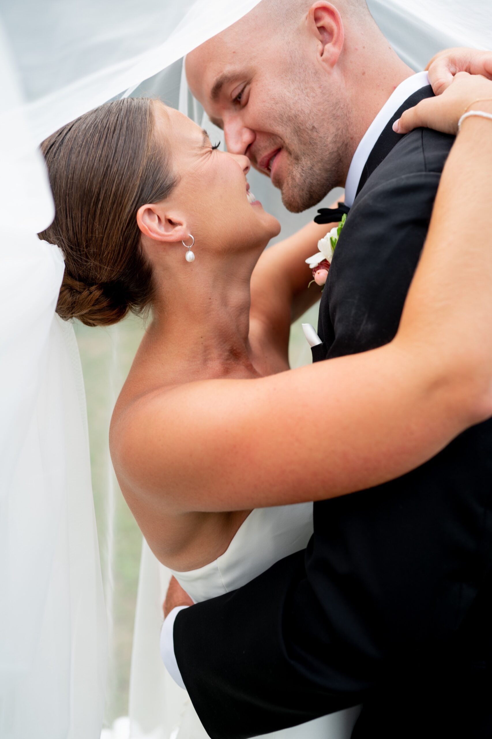 bride and groom about to kiss underneath the bride's veil 