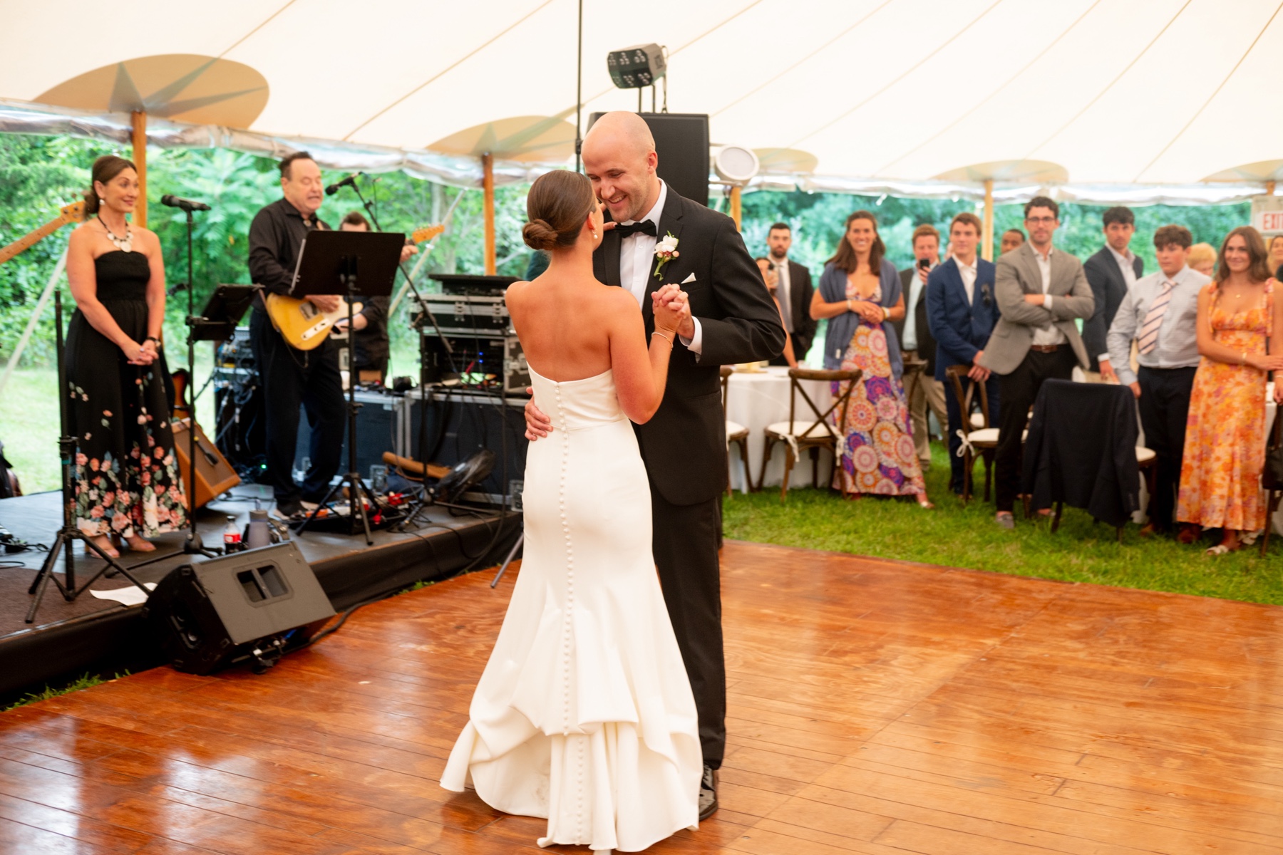 bride and groom dancing on the wooden dance floor as the guests watch during their Elegant South Shore Summer Wedding 