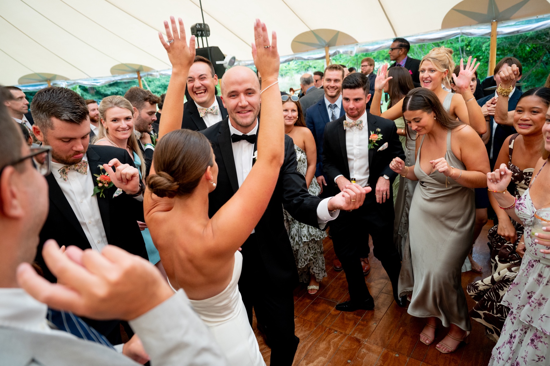 bride and groom dancing on the dance floor with all of their guests during the Elegant South Shore Summer Wedding reception 