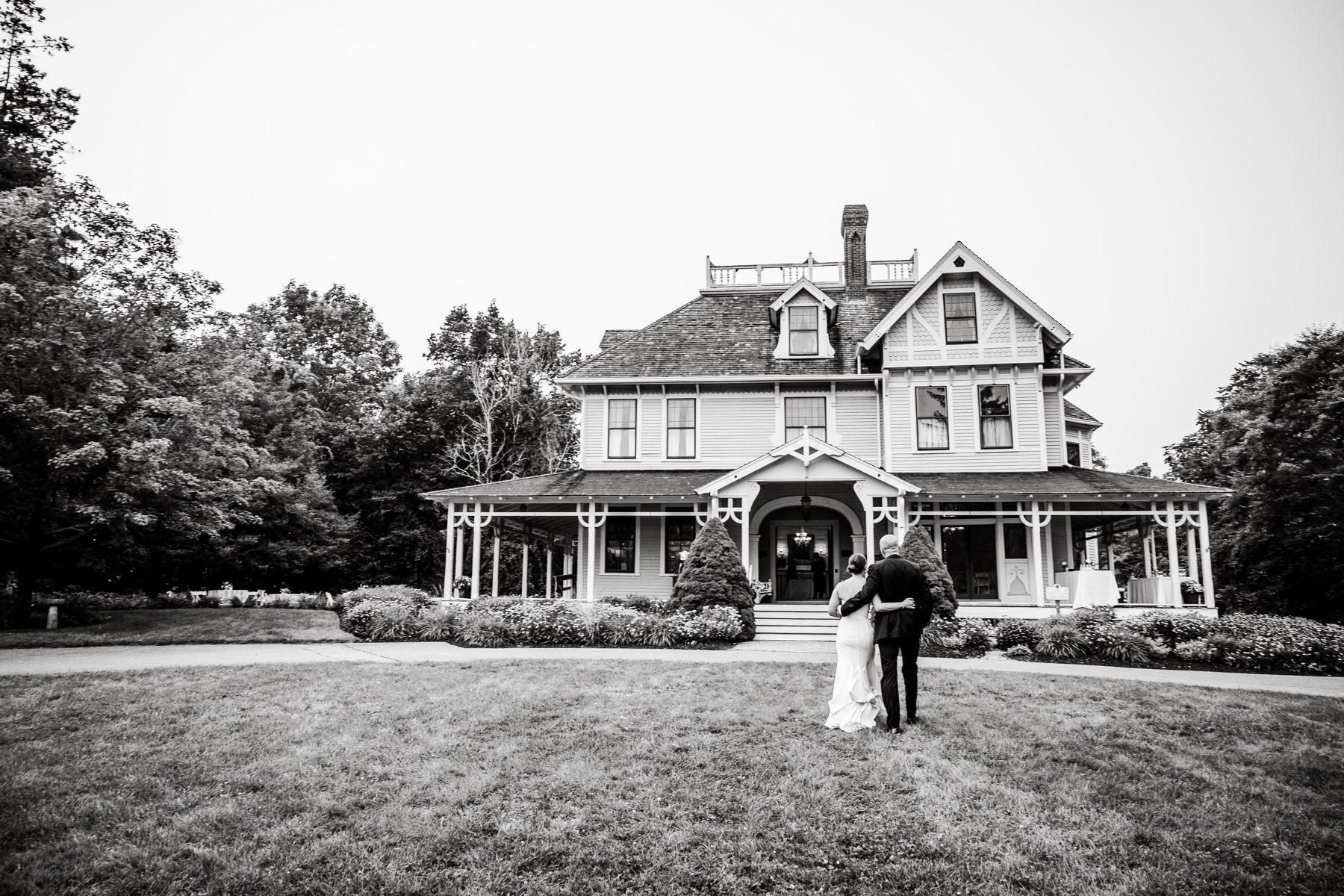 bride and groom walking up to wedding reception house 