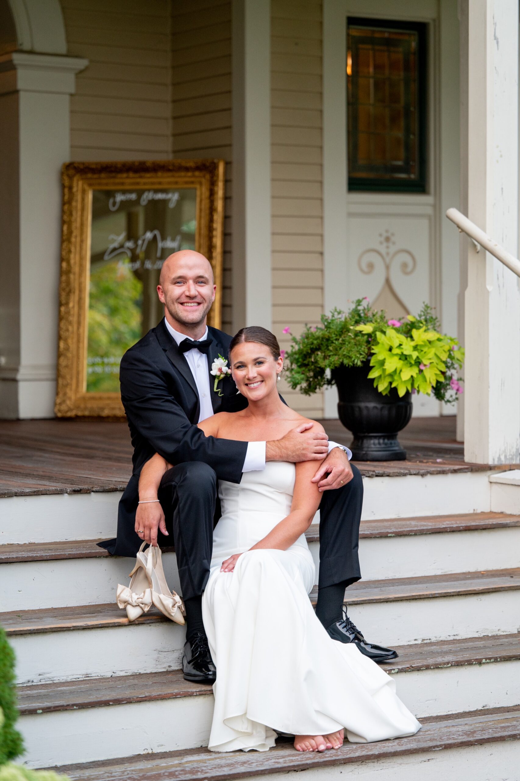 bride and groom sitting on the front steps after their South Shore Summer Wedding ceremony in Marshfield MA 