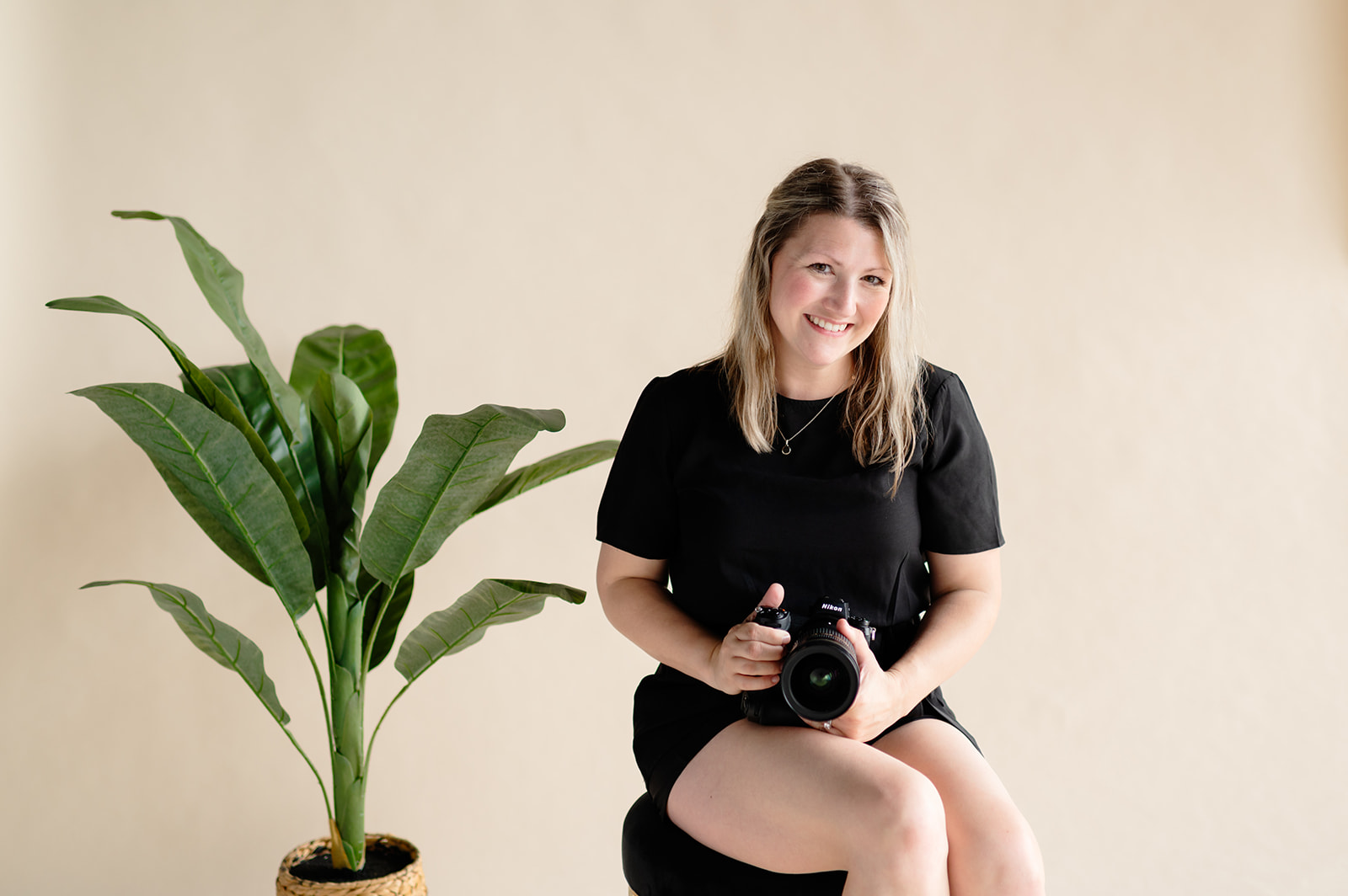 a Wedding Photographer sitting with her camera in the studio 