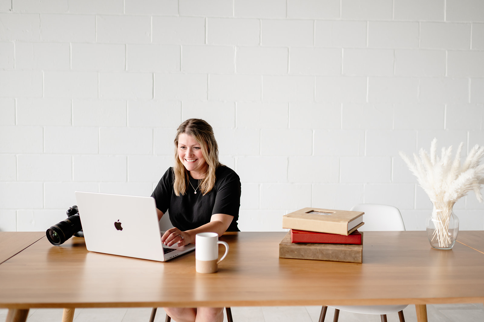 a wedding photographer sitting at her computer after a strong consultation call booked a happy client